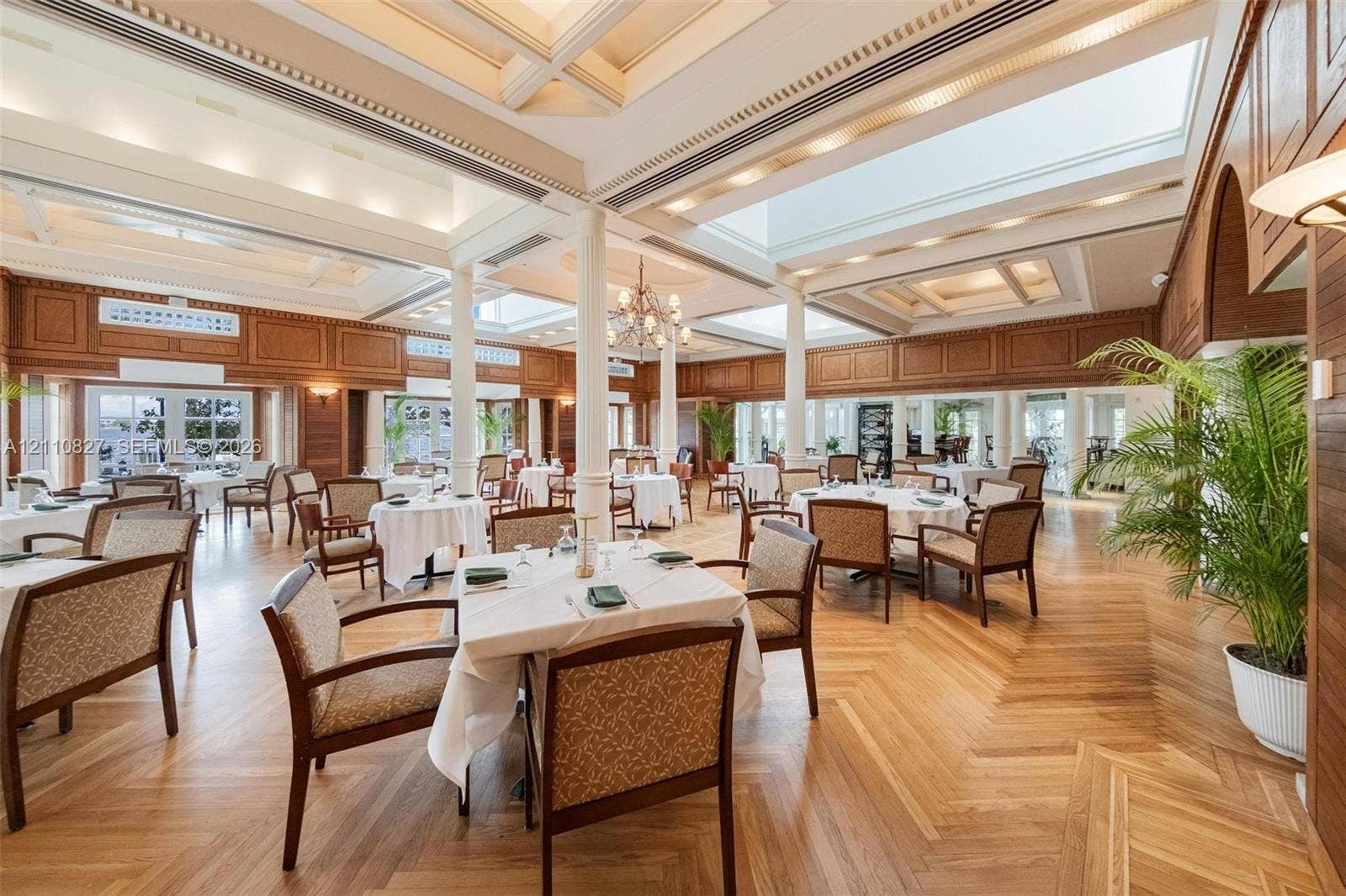 4000 Towerside Terrace, #908, Miami, Miami, FL 33138 Expansive interior space featuring coffered ceilings, skylights, intricate wall paneling, structural columns, and herringbone-pattern wood-finish flooring