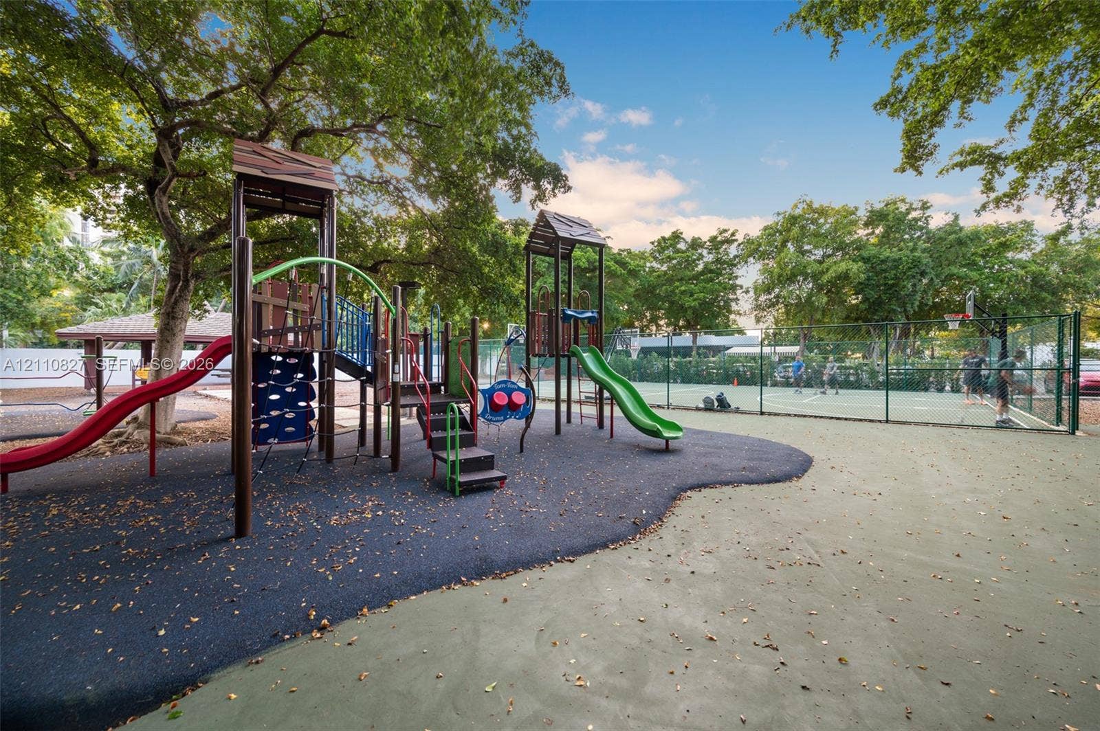 4000 Towerside Terrace, #908, Miami, Miami, FL 33138 Recreational area featuring a multi-component playground structure, paved sport court, fenced perimeter, and mature canopy trees