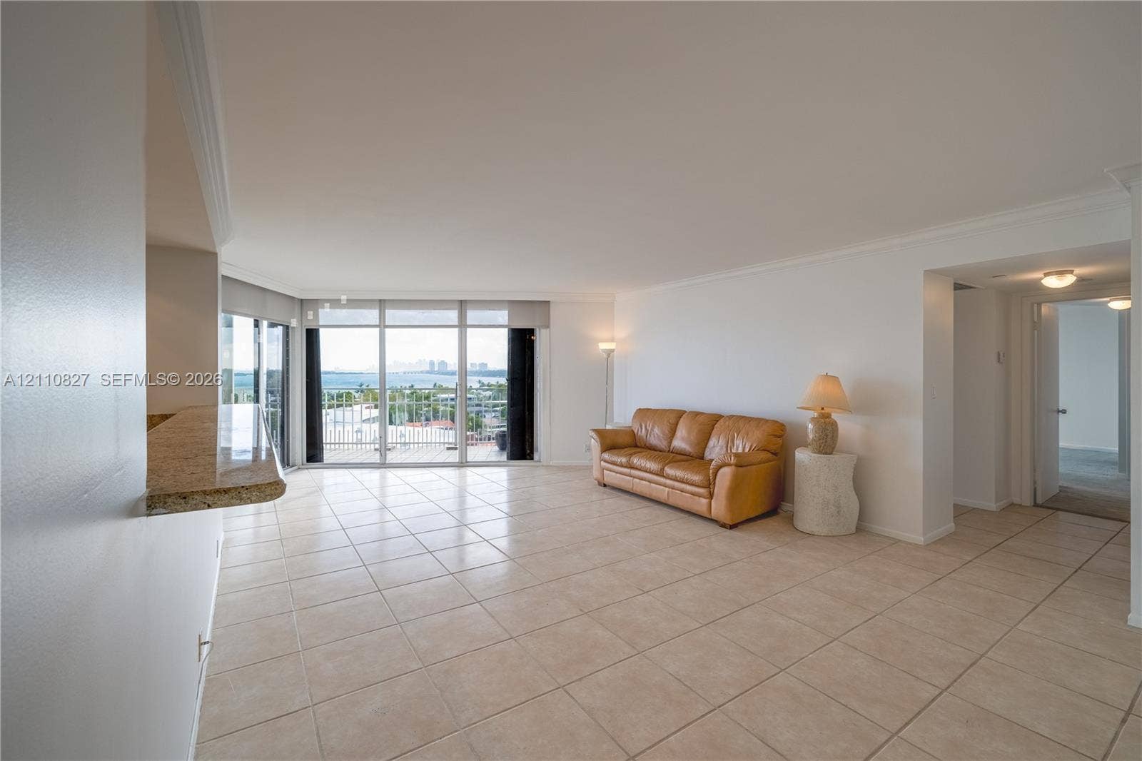 4000 Towerside Terrace, #908, Miami, Miami, FL 33138 Open-concept interior featuring large-format tile flooring, floor-to-ceiling glass wall, built-in stone-surface breakfast bar, and recessed lighting