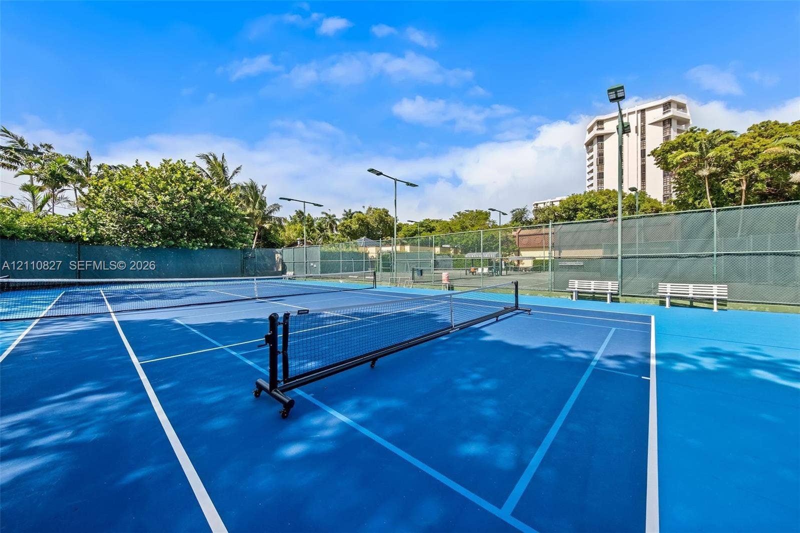 4000 Towerside Terrace, #908, Miami, Miami, FL 33138 Professional tennis courts featuring vibrant blue hard courts with white line markings, regulation net systems, and full perimeter fencing