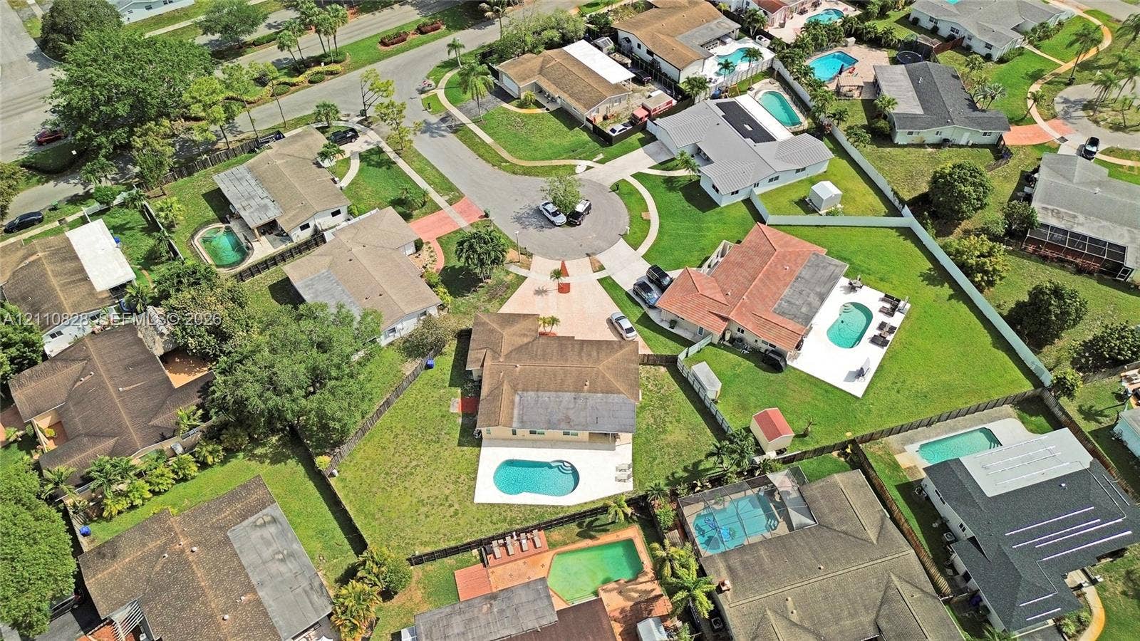 1600 NW 120th Avenue, Pembroke Pines, FL 33026 Aerial view of a residential property featuring an in-ground swimming pool, a concrete patio, and a manicured lawn