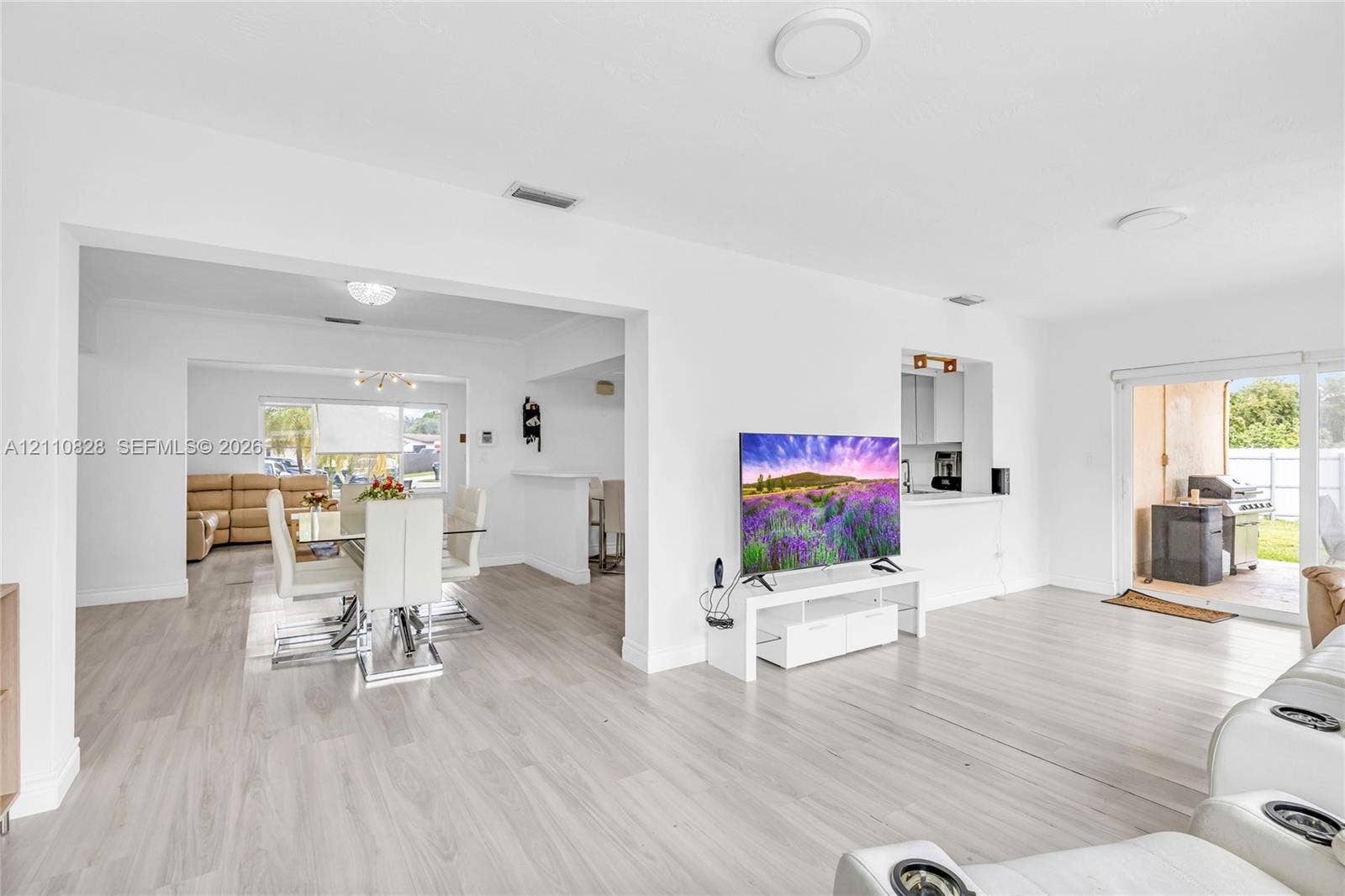 1600 NW 120th Avenue, Pembroke Pines, FL 33026 Open-concept interior featuring wood-finish flooring, recessed lighting, and sliding glass doors providing outdoor access