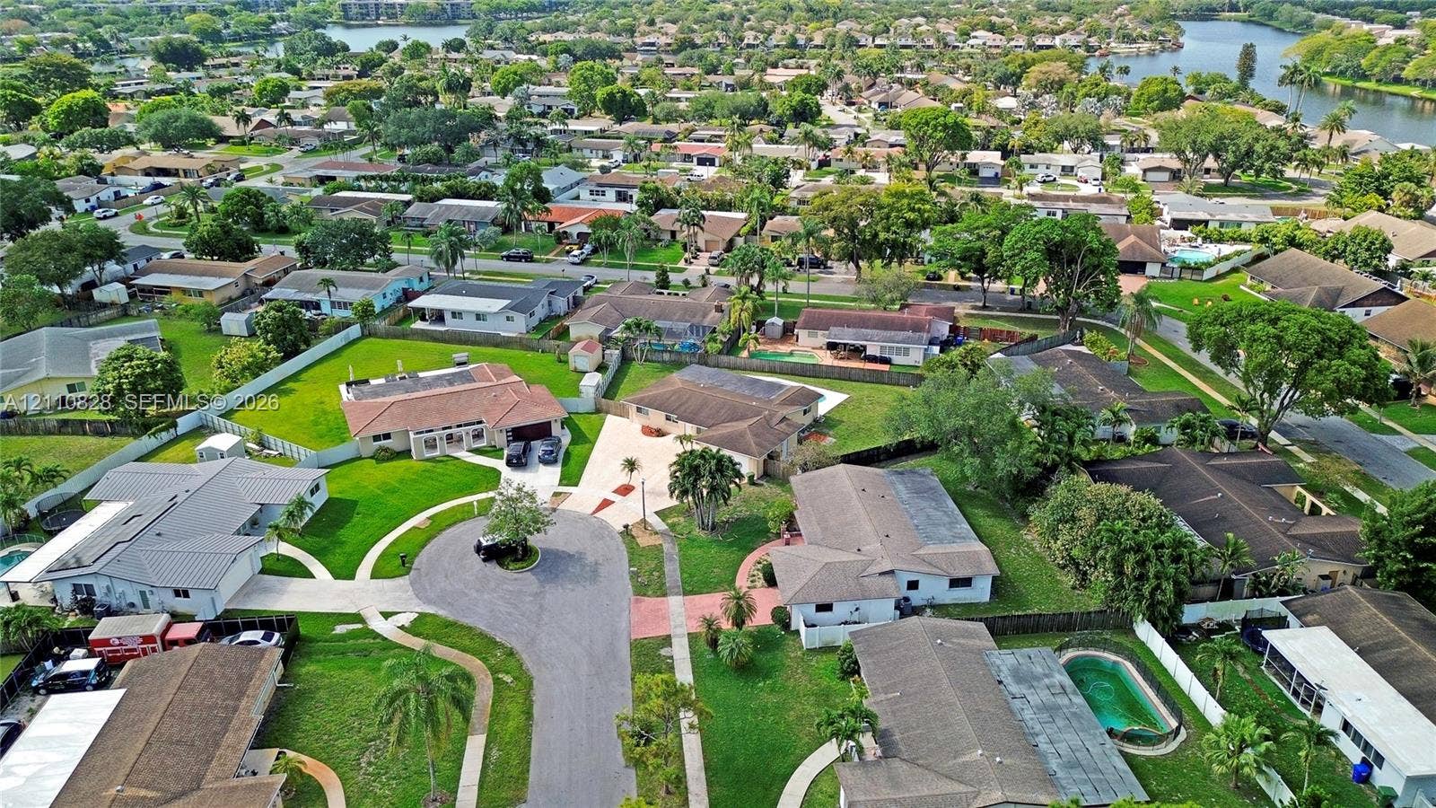 1600 NW 120th Avenue, Pembroke Pines, FL 33026 Aerial perspective of a suburban neighborhood featuring a cul-de-sac, winding roadways, mature trees, manicured lawns, and proximity to a waterway