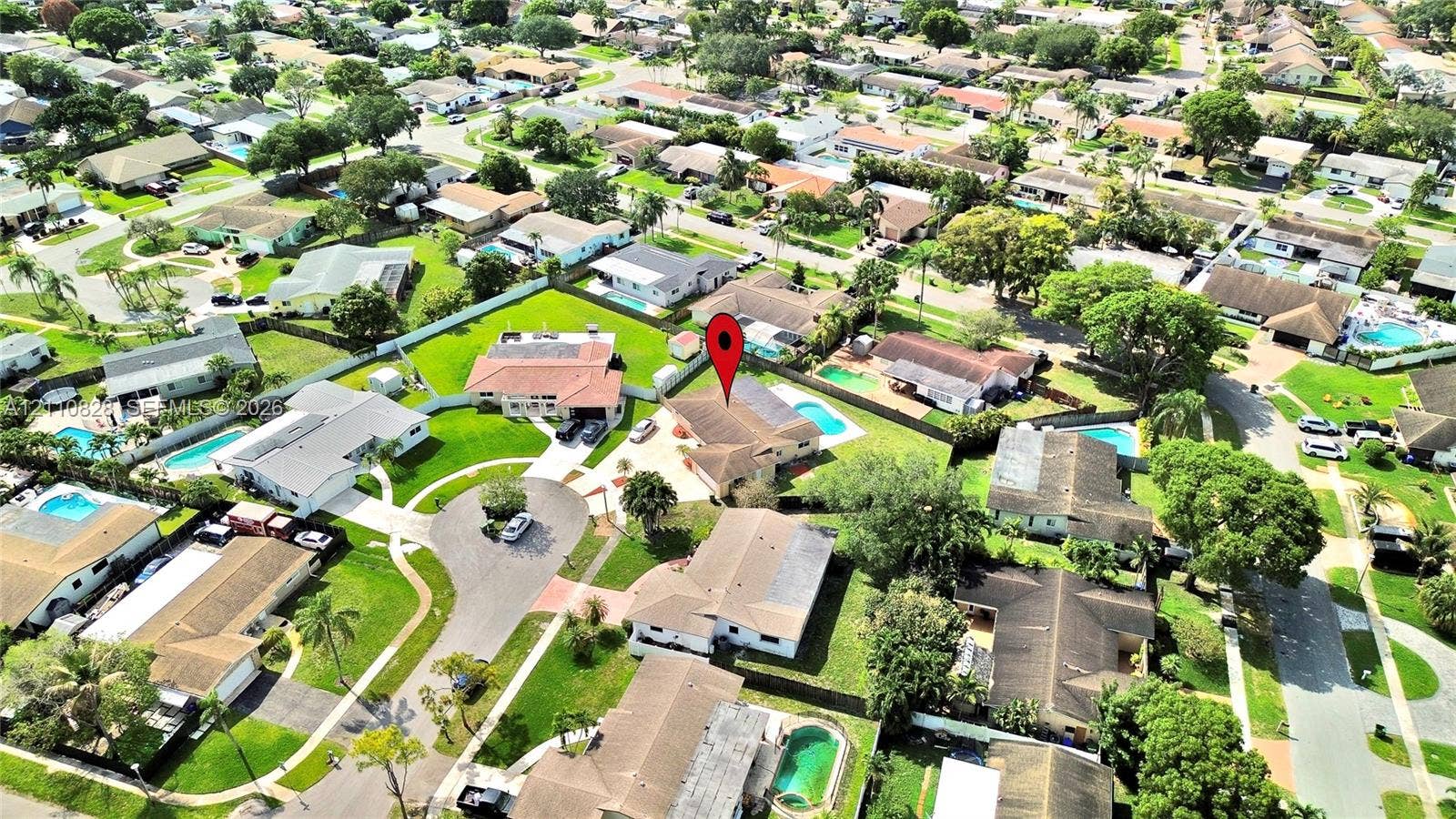1600 NW 120th Avenue, Pembroke Pines, FL 33026 Aerial perspective of a suburban neighborhood featuring residential lots with mature trees, established landscaping, paved roadways, and private swimming pools