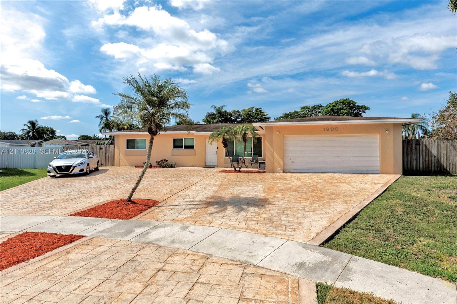1600 NW 120th Avenue, Pembroke Pines, FL 33026 Single-story exterior featuring a stamped concrete driveway, two-car garage, and palm-accented landscaping