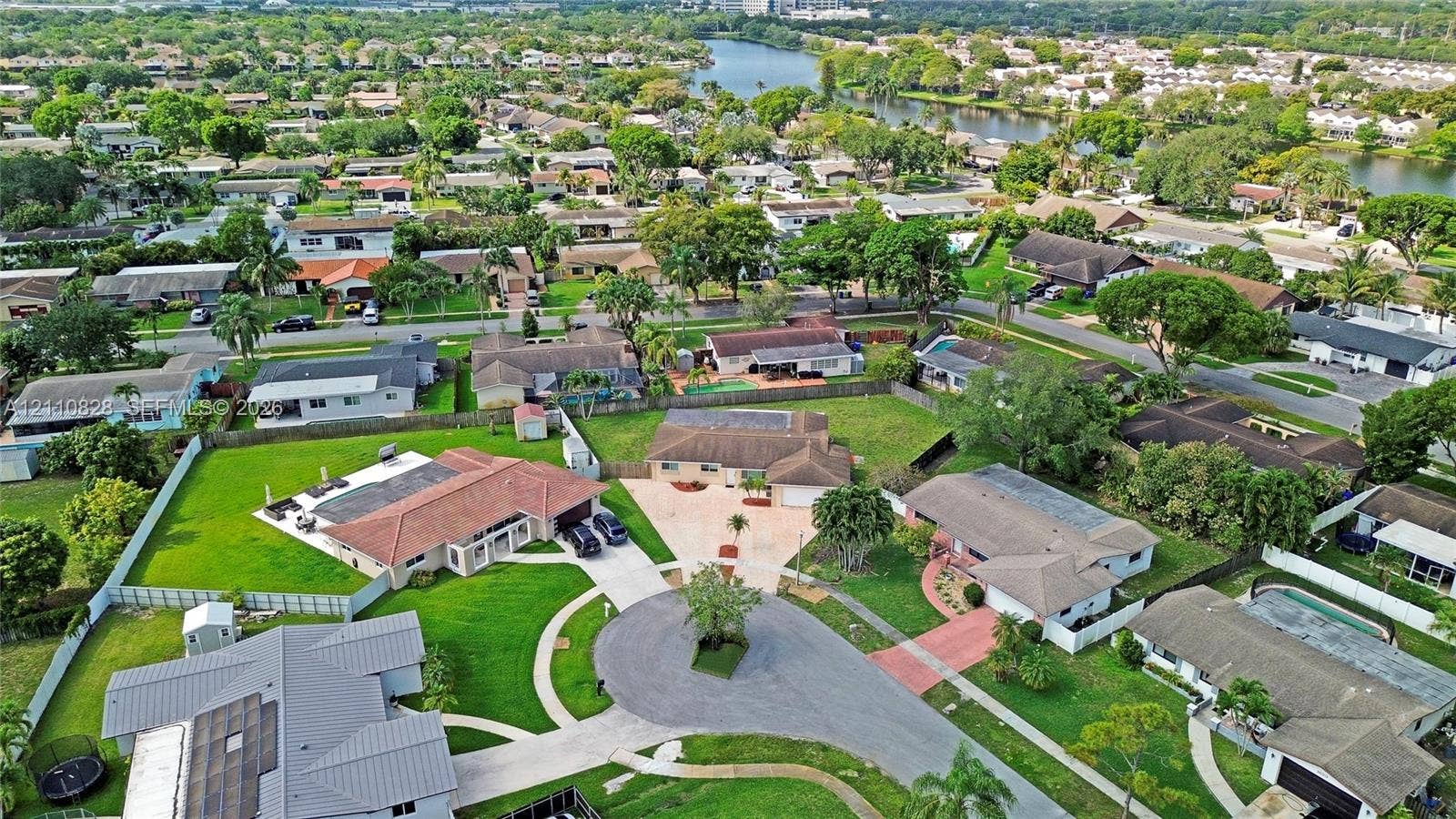 1600 NW 120th Avenue, Pembroke Pines, FL 33026 Aerial perspective of a cul-de-sac residential location featuring expansive corner lots, multi-pitched shingle roofing, paved driveways, and established mature landscaping