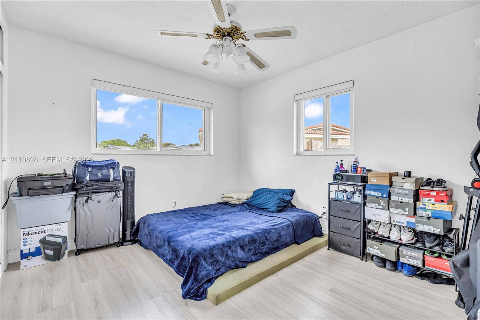 1600 NW 120th Avenue, Pembroke Pines, FL 33026 Neutral-toned wood-finish flooring, dual sliding-sash windows, and a multi-blade ceiling fan with integrated lighting
