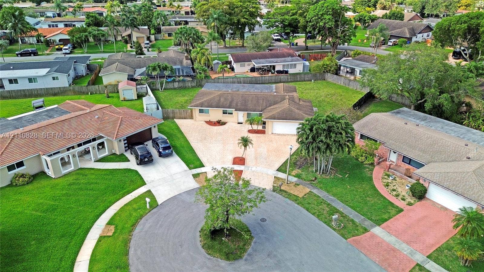 1600 NW 120th Avenue, Pembroke Pines, FL 33026 Aerial perspective of a single-story residence situated on a cul-de-sac lot, featuring a paver driveway, an attached garage, and a fenced backyard