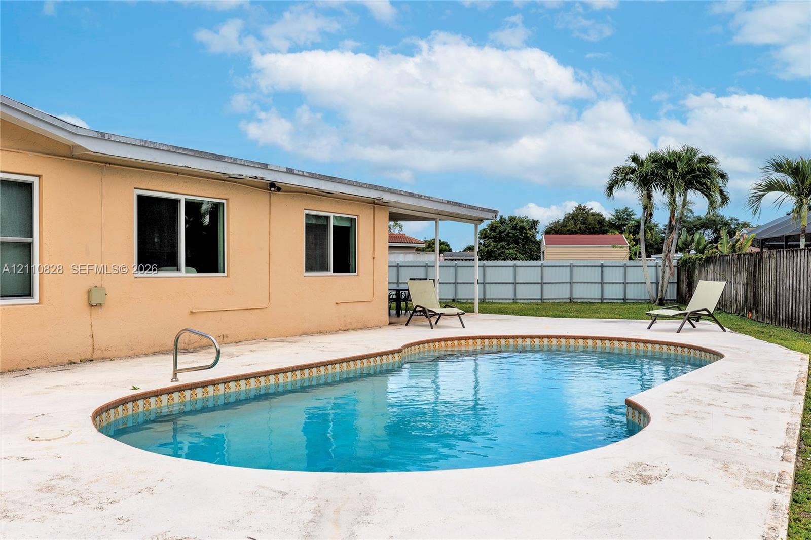1600 NW 120th Avenue, Pembroke Pines, FL 33026 In-ground swimming pool with a concrete pool deck, covered patio, and perimeter fencing