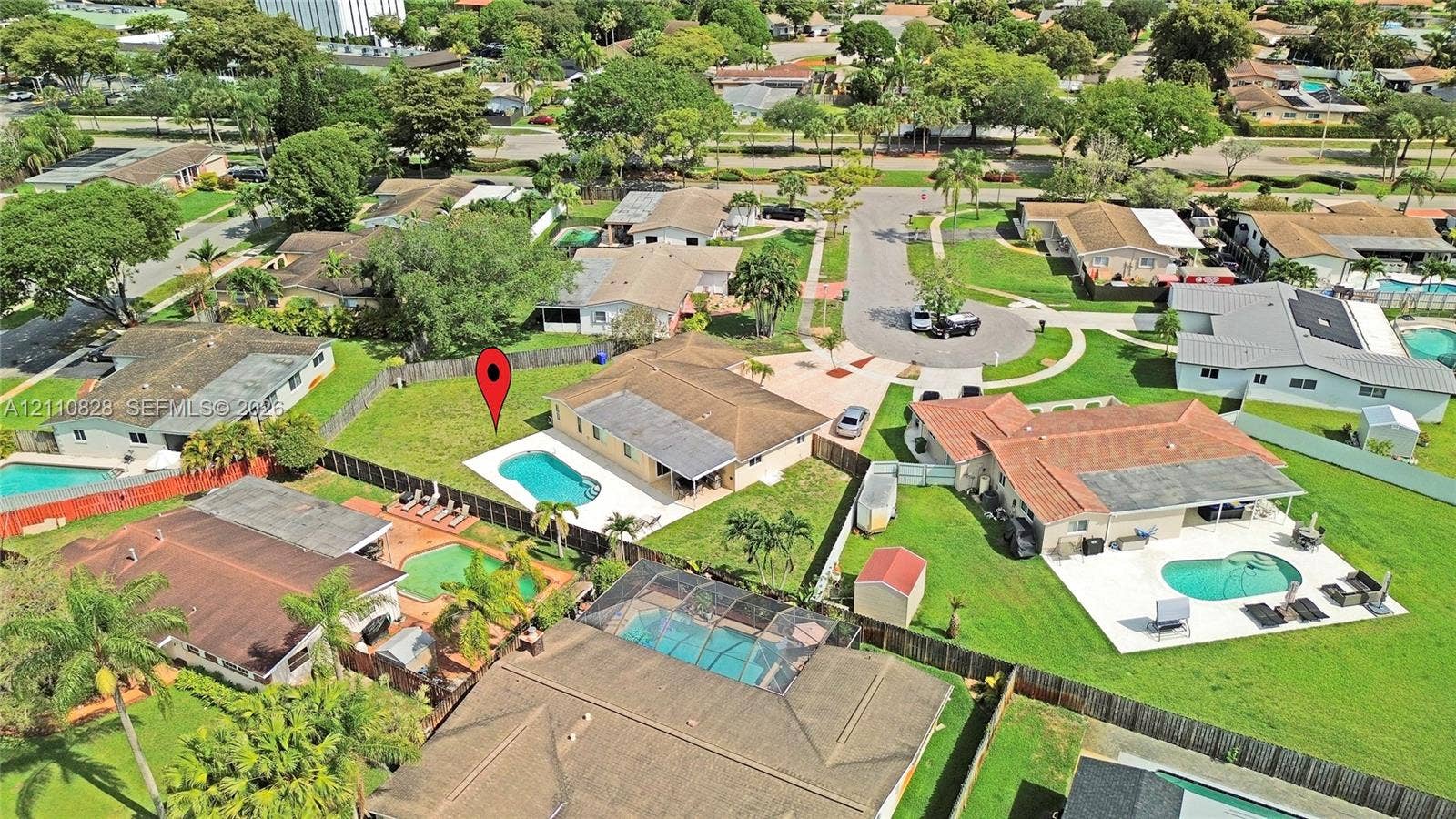1600 NW 120th Avenue, Pembroke Pines, FL 33026 Aerial perspective of a single-story residence featuring a concrete-tiled hip roof, an in-ground swimming pool, a concrete patio, and a fenced backyard