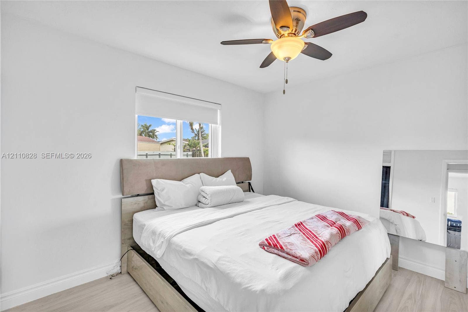 1600 NW 120th Avenue, Pembroke Pines, FL 33026 Light-filled room featuring wood-finish flooring, a neutral color palette, and an integrated ceiling fan with light fixture