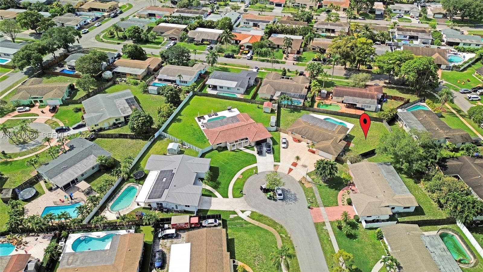 1600 NW 120th Avenue, Pembroke Pines, FL 33026 Aerial perspective featuring a residential property with a multi-hipped roofline, an attached multi-car garage, and a private rear swimming pool situated on a spacious corner lot