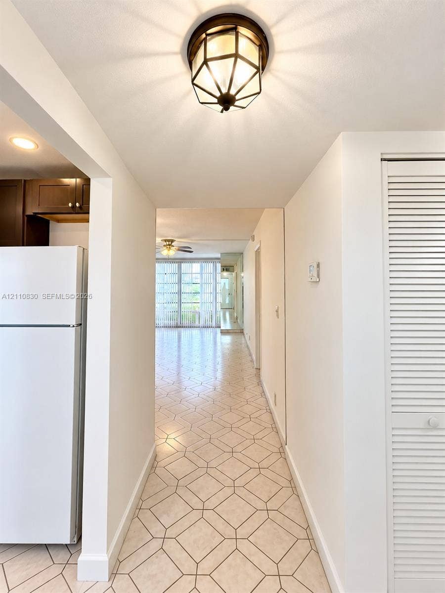 Geometric patterned tile flooring, hexagonal light fixture with oil-rubbed bronze finish, and louvered bifold closet doors