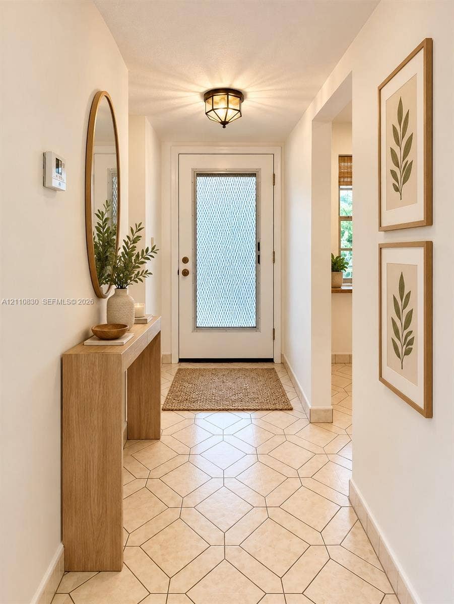 STAGED Entryway featuring geometric patterned tile flooring, an exterior door with textured glass insert, and a flush-mount lantern-style light fixture
