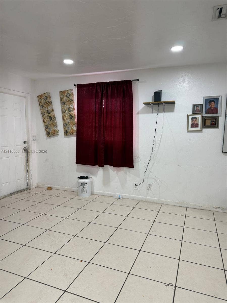 Interior space featuring square tile flooring and recessed ceiling lighting