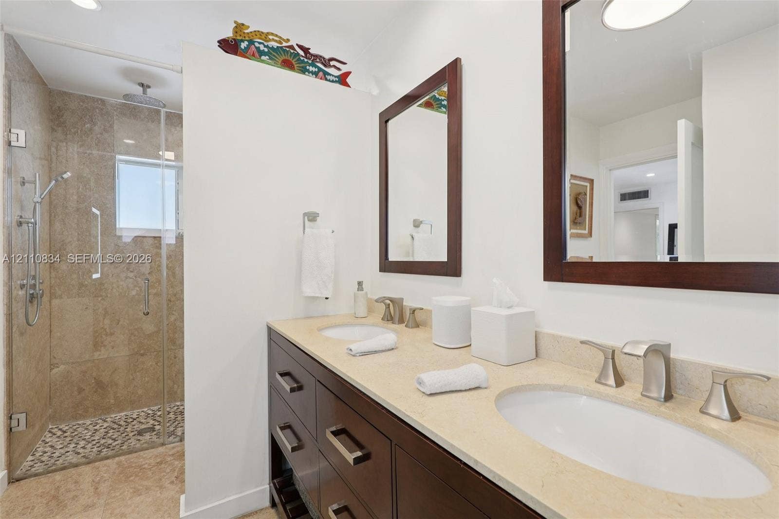 4120 SW 15th Street, Miami, FL 33142 Double vanity with stone countertop, dark wood-finish cabinetry, frameless glass shower enclosure, stone-tiled shower wall, and integrated shower rainfall fixture