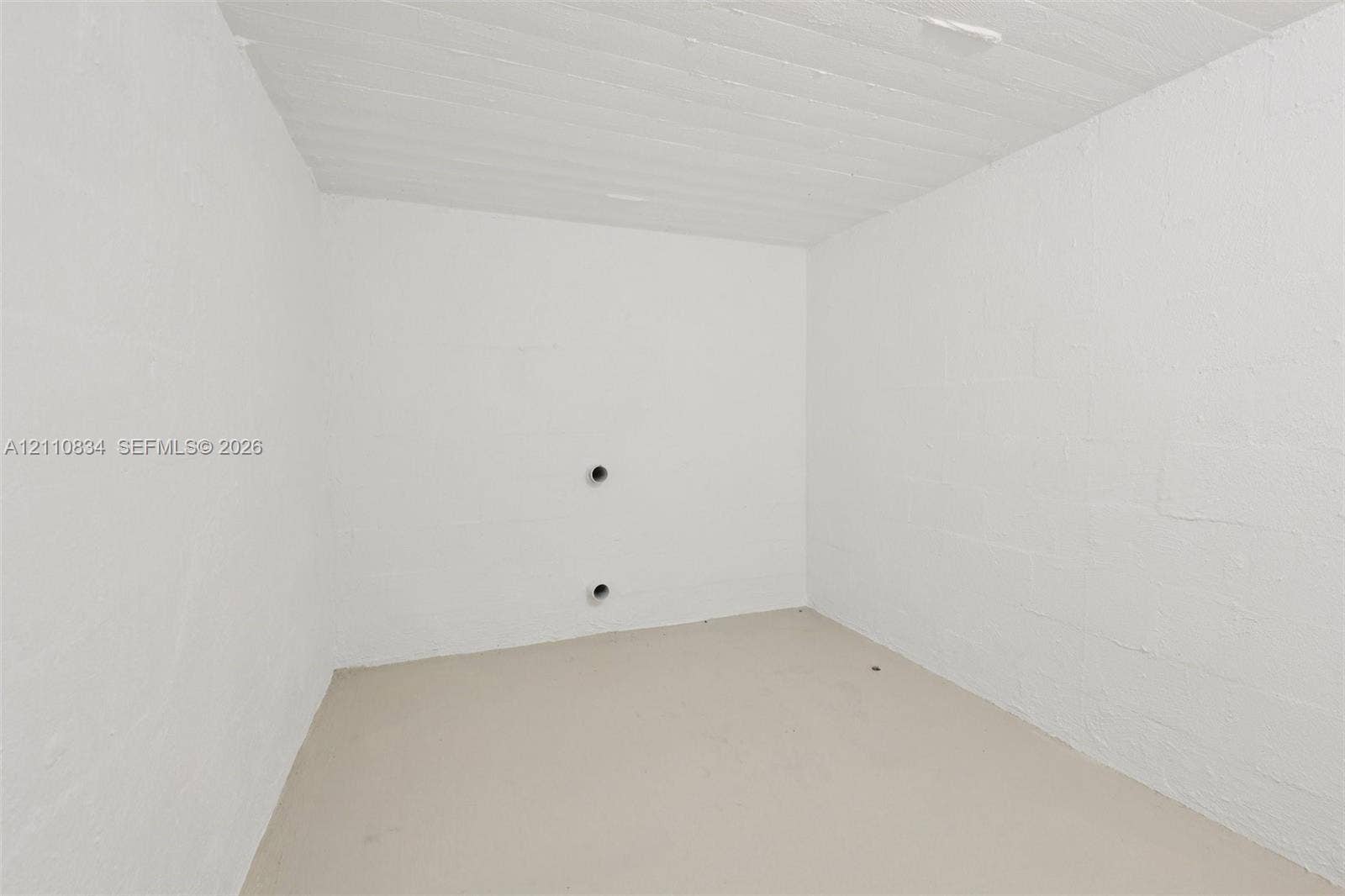4120 SW 15th Street, Miami, FL 33142 Enclosed space featuring white-painted masonry walls, a painted concrete floor, and a textured ceiling