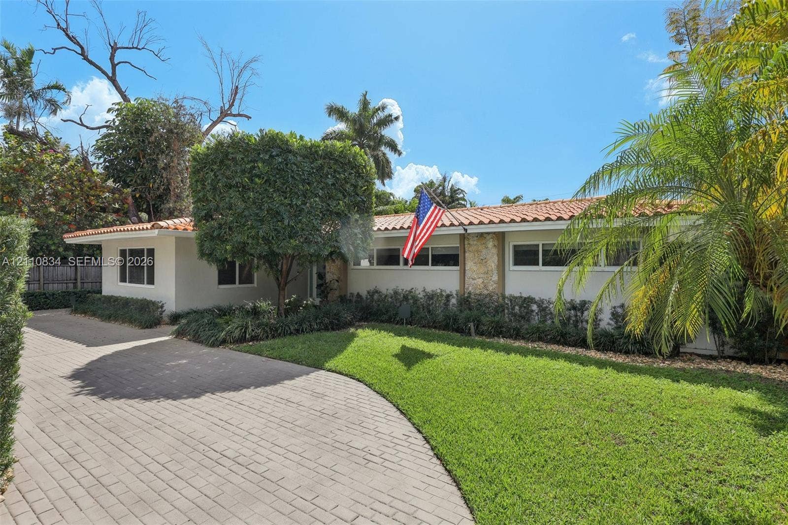 4120 SW 15th Street, Miami, FL 33142 Single-story exterior featuring a clay tile roof, stone masonry facade accents, and a paved brick driveway
