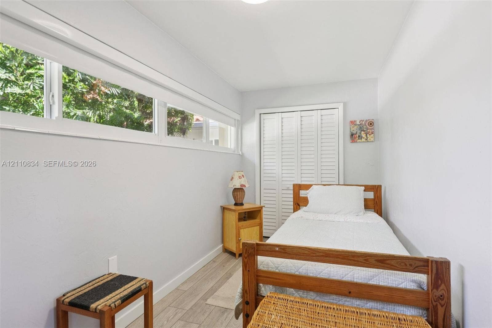 4120 SW 15th Street, Miami, FL 33142 Room featuring wood-finish tile flooring, horizontally aligned windows, and louvered-panel closet doors