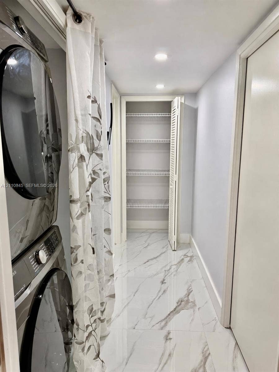 565 Oaks Lane, #410, Pompano Beach, FL 33069 Utility space featuring large-format stone-look porcelain tile flooring, recessed ceiling lighting, and a built-in closet with ventilated wire shelving