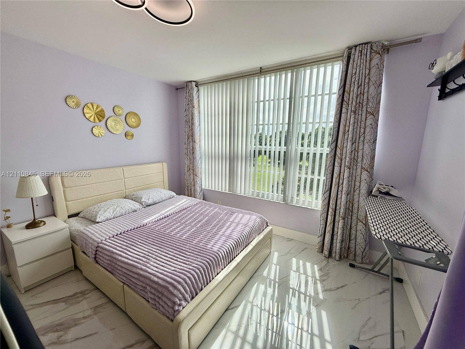565 Oaks Lane, #410, Pompano Beach, FL 33069 Large floor-to-ceiling windows with vertical blinds, stone-finish flooring, and modern geometric ceiling fixture