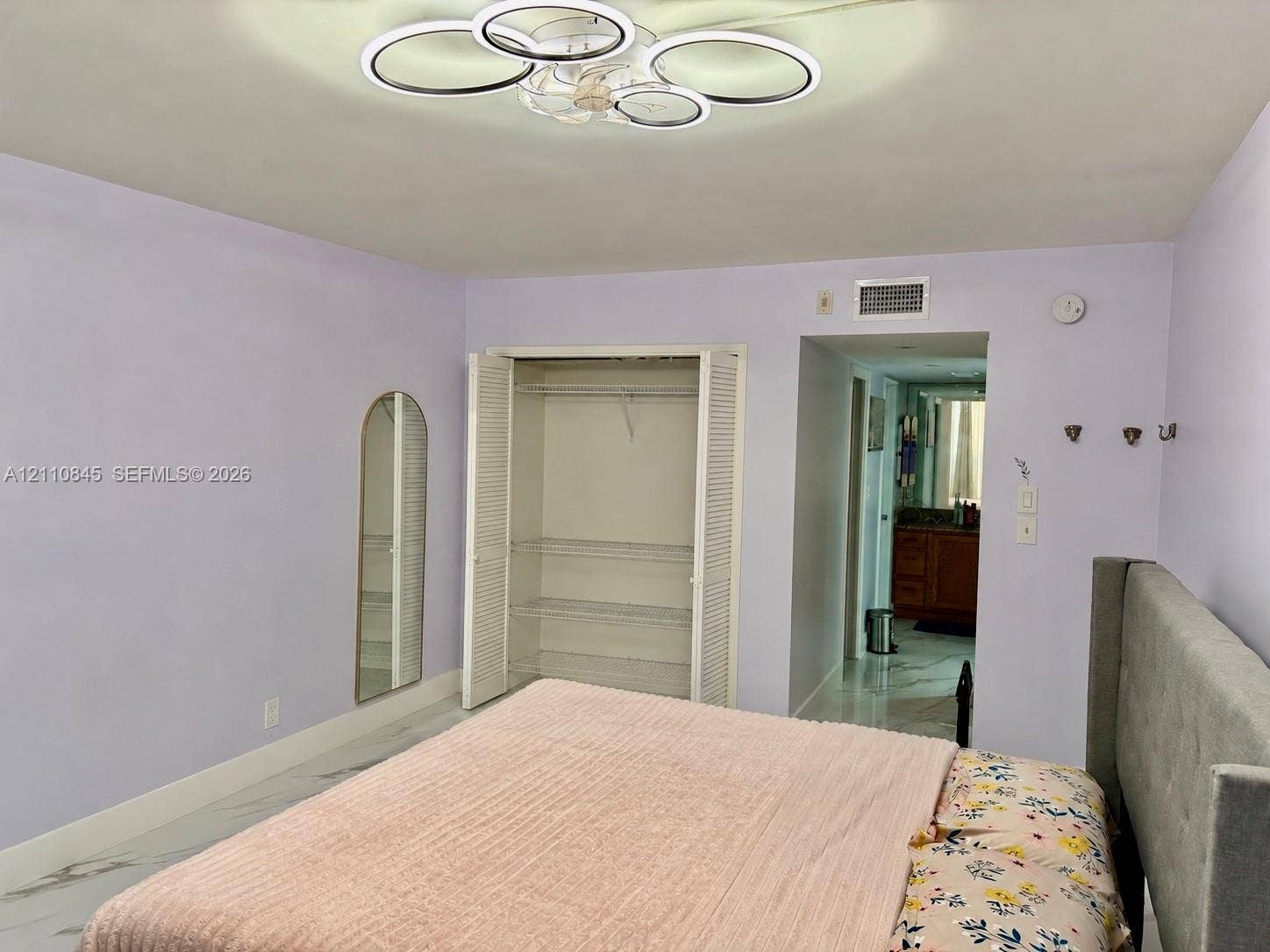 565 Oaks Lane, #410, Pompano Beach, FL 33069 Multi-ring LED flush-mount fixture, closet with louvered bi-fold doors and integrated shelving, and large-format tile flooring