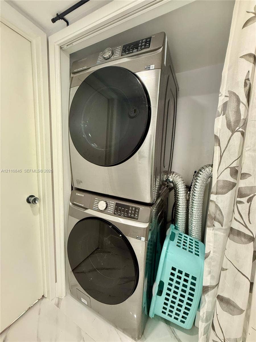 565 Oaks Lane, #410, Pompano Beach, FL 33069 Stacked front-load washer and dryer in stainless steel finish with digital control panels