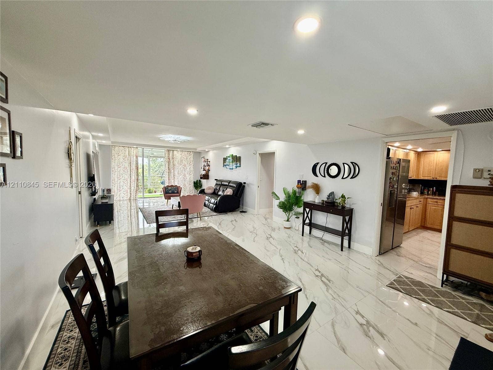 565 Oaks Lane, #410, Pompano Beach, FL 33069 Large-format polished tile flooring, recessed ceiling lighting, and sliding glass doors with exterior access