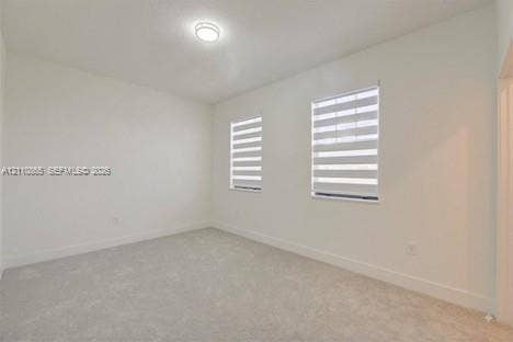 17552 SW 46th Street, Miramar, Miramar, FL 33029 Neutral-toned carpeted flooring, white wall finishes, dual windows featuring adjustable banded roller shades, and a central flush-mount ceiling light fixture