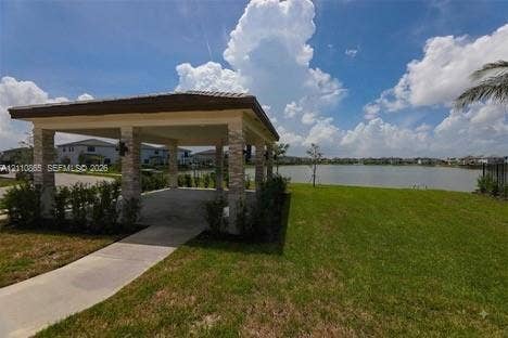 17552 SW 46th Street, Miramar, Miramar, FL 33029 Covered pavilion featuring stone-clad pillars, concrete flooring, and a tiled roof, set against a waterfront backdrop