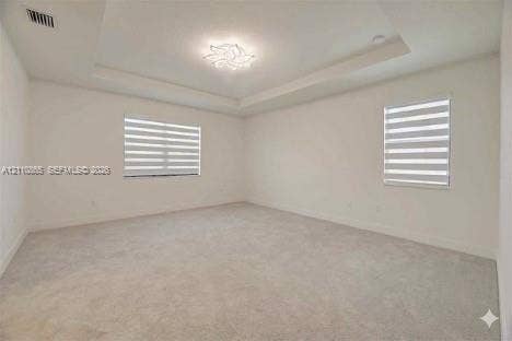 17552 SW 46th Street, Miramar, Miramar, FL 33029 Tray ceiling featuring a contemporary flush-mount light fixture, wall-to-wall carpeting, and dual windows with layered zebra-style roller shades