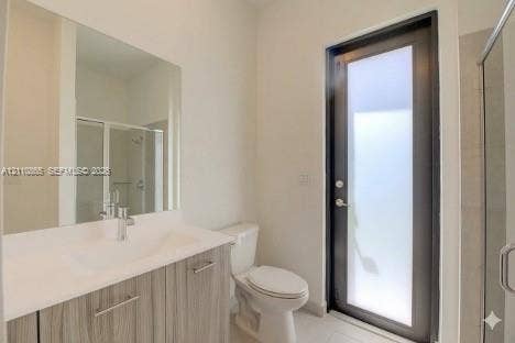 17552 SW 46th Street, Miramar, Miramar, FL 33029 Bathroom featuring a vanity with a light wood-finish cabinet and solid surface countertop, an oversized wall-mounted mirror, a full-height glass-panel door, and a glass-enclosed shower