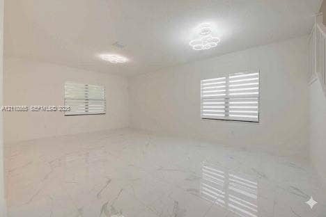 17552 SW 46th Street, Miramar, Miramar, FL 33029 Large room featuring polished stone-finish tile flooring, dual modern floral-style flush-mount lighting fixtures, and dual-layered horizontal window shades