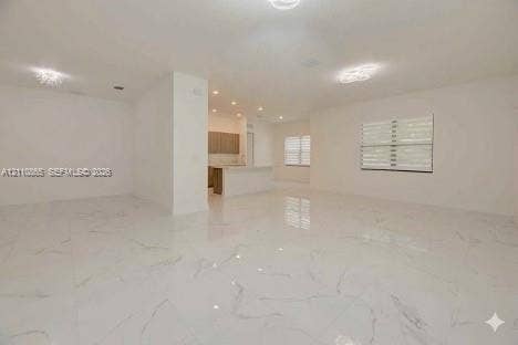 17552 SW 46th Street, Miramar, Miramar, FL 33029 Open-concept interior featuring large-format tile flooring with veined detailing, recessed ceiling lighting, decorative flush-mount fixtures, and windows fitted with horizontal blinds