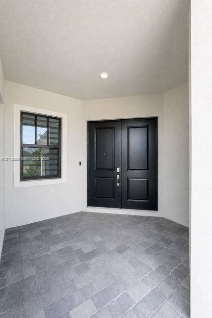 17552 SW 46th Street, Miramar, Miramar, FL 33029 Covered entryway featuring double doors with matte black finish, stone-paver flooring, and a multi-pane window with dark trim
