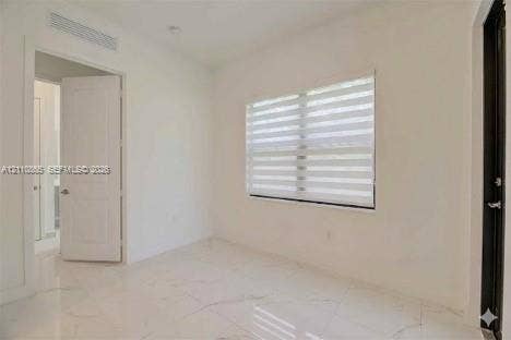 17552 SW 46th Street, Miramar, Miramar, FL 33029 Interior space featuring light-toned stone-finish flooring, dual-panel interior door, banded window shades, and minimalist trim