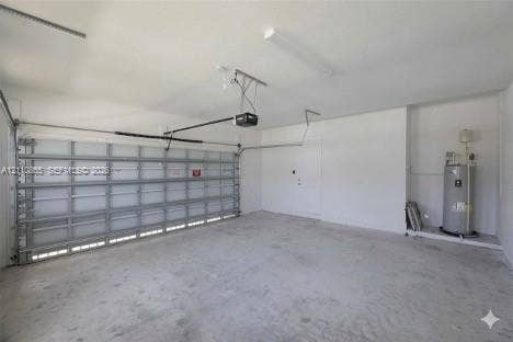 17552 SW 46th Street, Miramar, Miramar, FL 33029 Multi-car garage featuring a concrete floor, sectional roll-up door, automated door opener, finished walls, and an integrated water heater