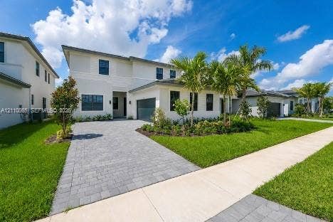 17552 SW 46th Street, Miramar, Miramar, FL 33029 Two-story residence featuring a light-toned exterior, paved driveway, multi-pane windows, attached garage, and landscaped front lawn with palm trees