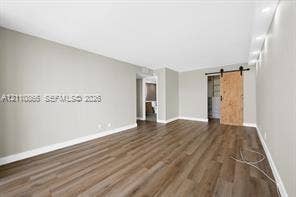 Interior space featuring wood-finish flooring, recessed lighting, and a sliding barn door with matte black hardware