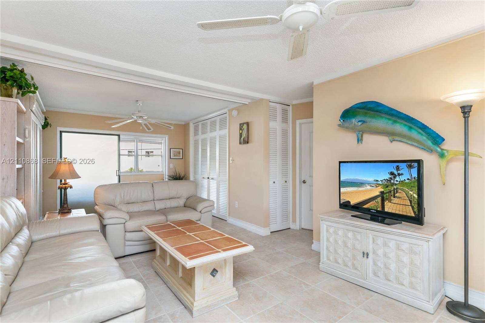 3121 S Ocean Drive, #209, Hallandale Beach, FL 33009 Neutral tile flooring, ceiling fans, and louvered-panel closet doors