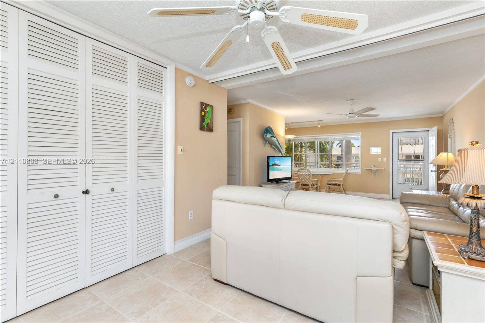 3121 S Ocean Drive, #209, Hallandale Beach, FL 33009 Full-height louvered closet doors, neutral ceramic tile flooring, and dual ceiling fans with integrated lighting