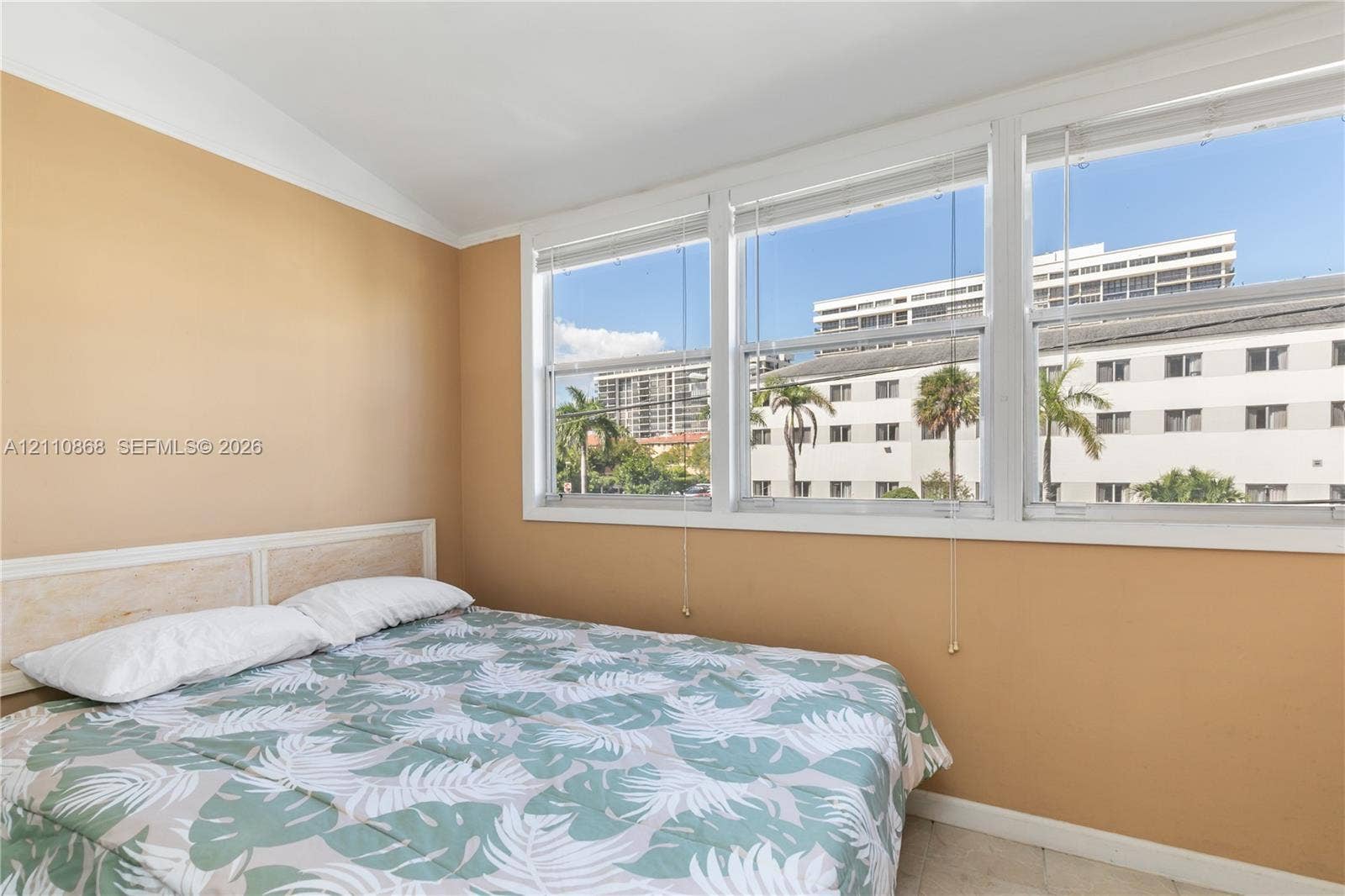 3121 S Ocean Drive, #209, Hallandale Beach, FL 33009 Enclosed back porch.Room featuring neutral-toned walls, vaulted ceilings, and a series of large, multi-pane windows with fitted blinds