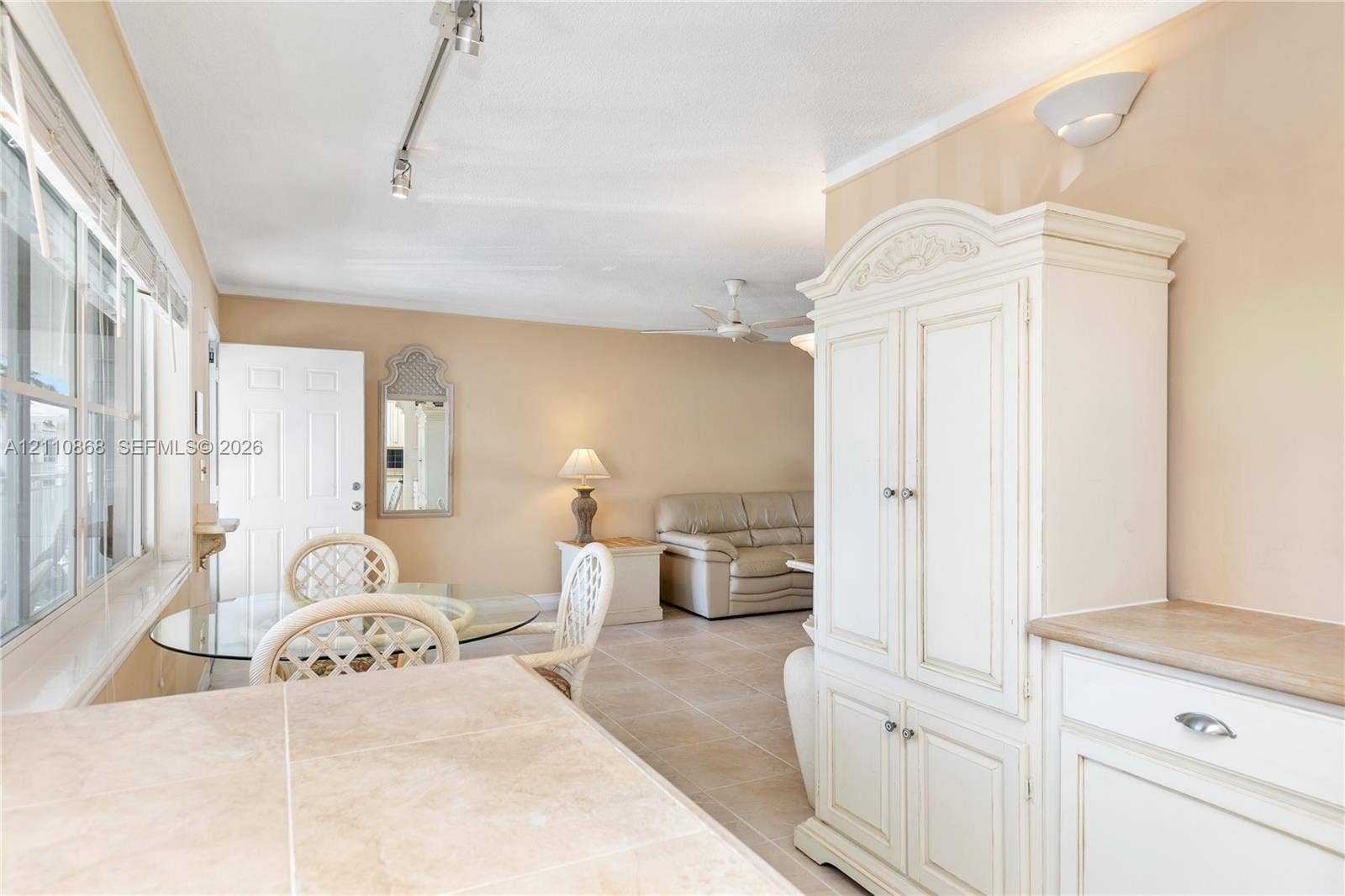 3121 S Ocean Drive, #209, Hallandale Beach, FL 33009 Interior featuring large-format tile flooring, built-in white cabinetry with stone-surface countertop, multi-pane windows, and track lighting