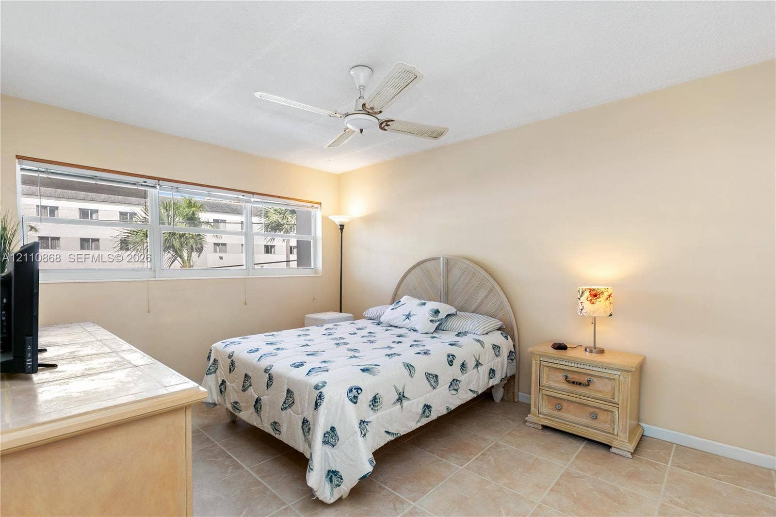 3121 S Ocean Drive, #209, Hallandale Beach, FL 33009 Neutral-toned interior space featuring light-colored tile flooring, wide-paneled window, and an integrated ceiling fan