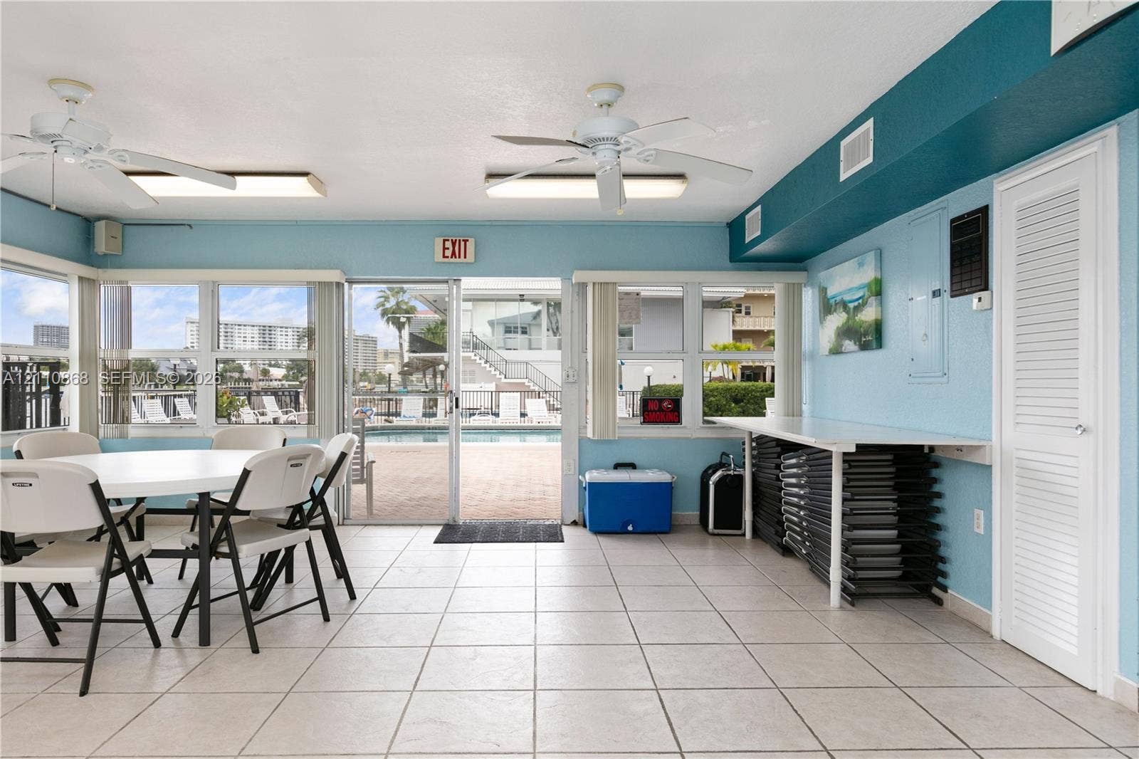3121 S Ocean Drive, #209, Hallandale Beach, FL 33009 Large windows, neutral tile flooring, dual ceiling fans, and a sliding glass door providing access to the pool area
