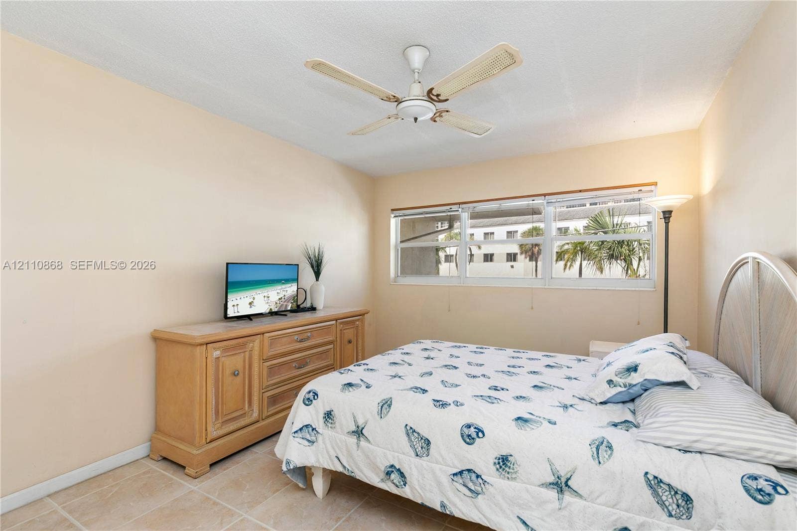 3121 S Ocean Drive, #209, Hallandale Beach, FL 33009 Neutral-toned walls, tile flooring, multi-pane windows, and a ceiling fan with integrated lighting