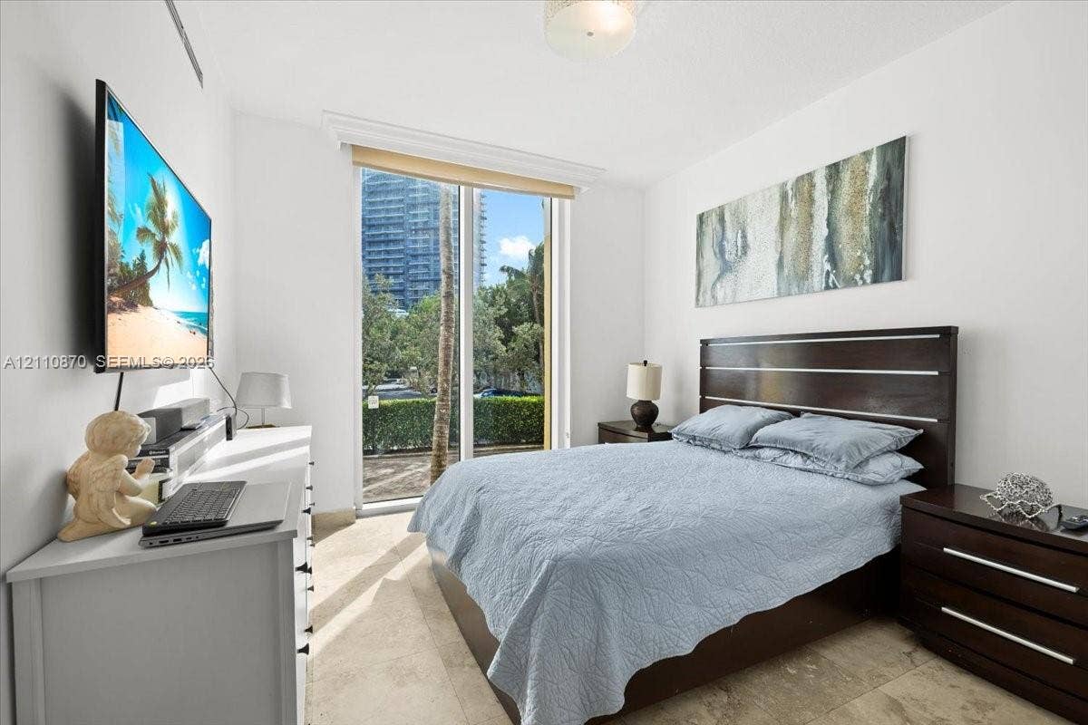 1755 E Hallandale Beach Boulevard, #MEZ5E, Hallandale Beach, FL 33009 Floor-to-ceiling glass door with window treatment and natural stone flooring
