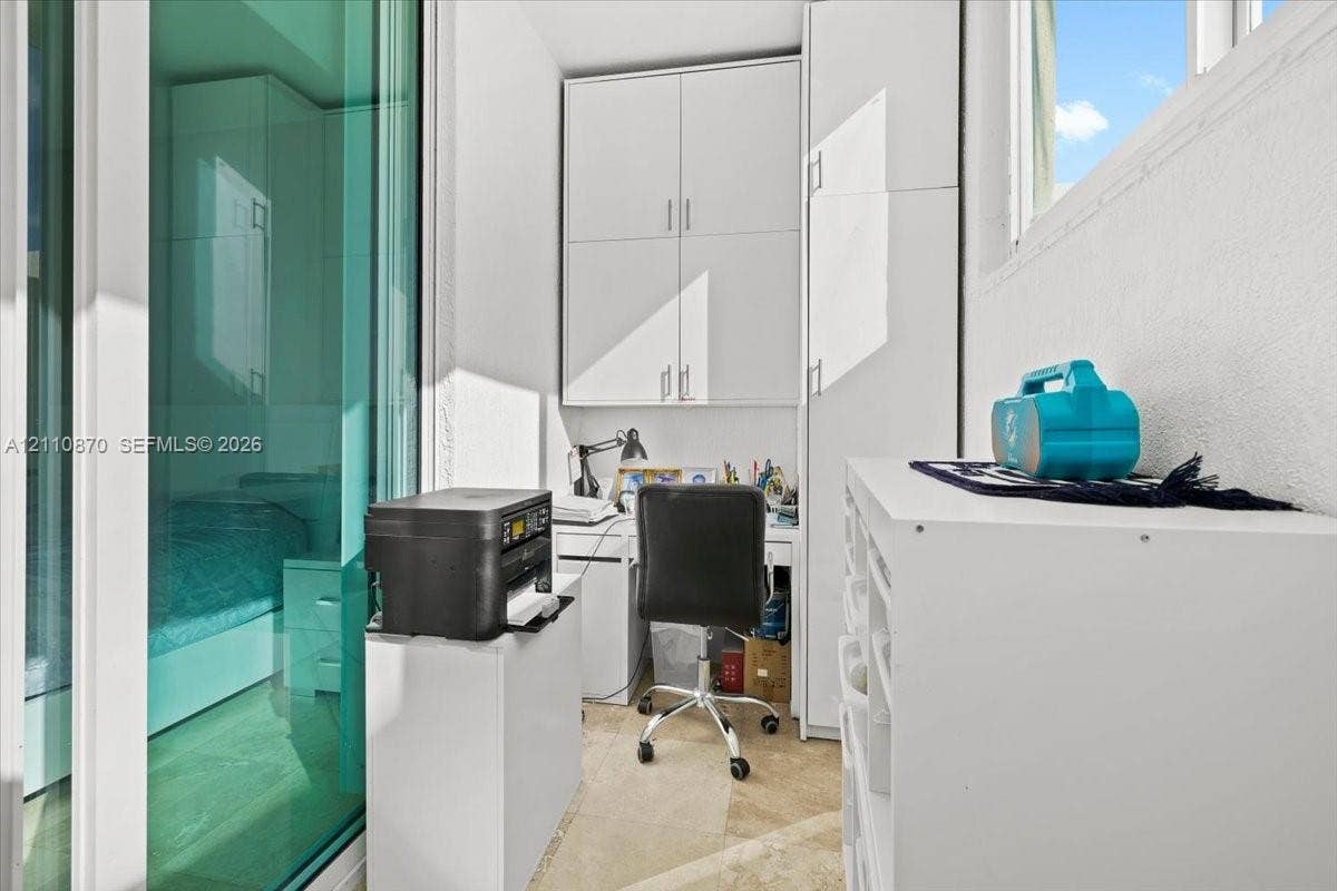1755 E Hallandale Beach Boulevard, #MEZ5E, Hallandale Beach, FL 33009 Built-in floor-to-ceiling white cabinetry, tile flooring, and sliding glass panel door