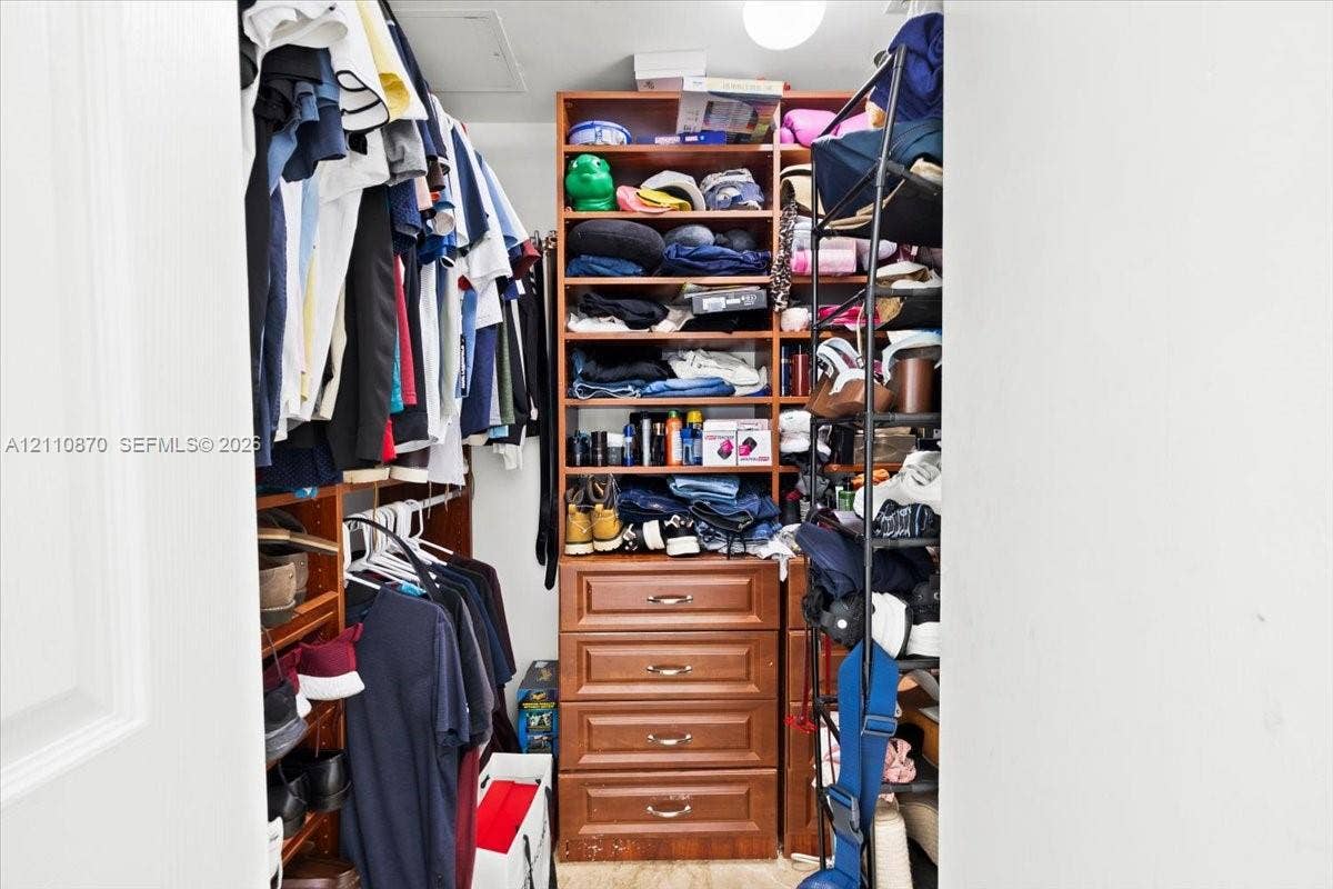 1755 E Hallandale Beach Boulevard, #MEZ5E, Hallandale Beach, FL 33009 Walk-in storage space featuring built-in wood-finish shelving and a stack of four integrated storage drawers