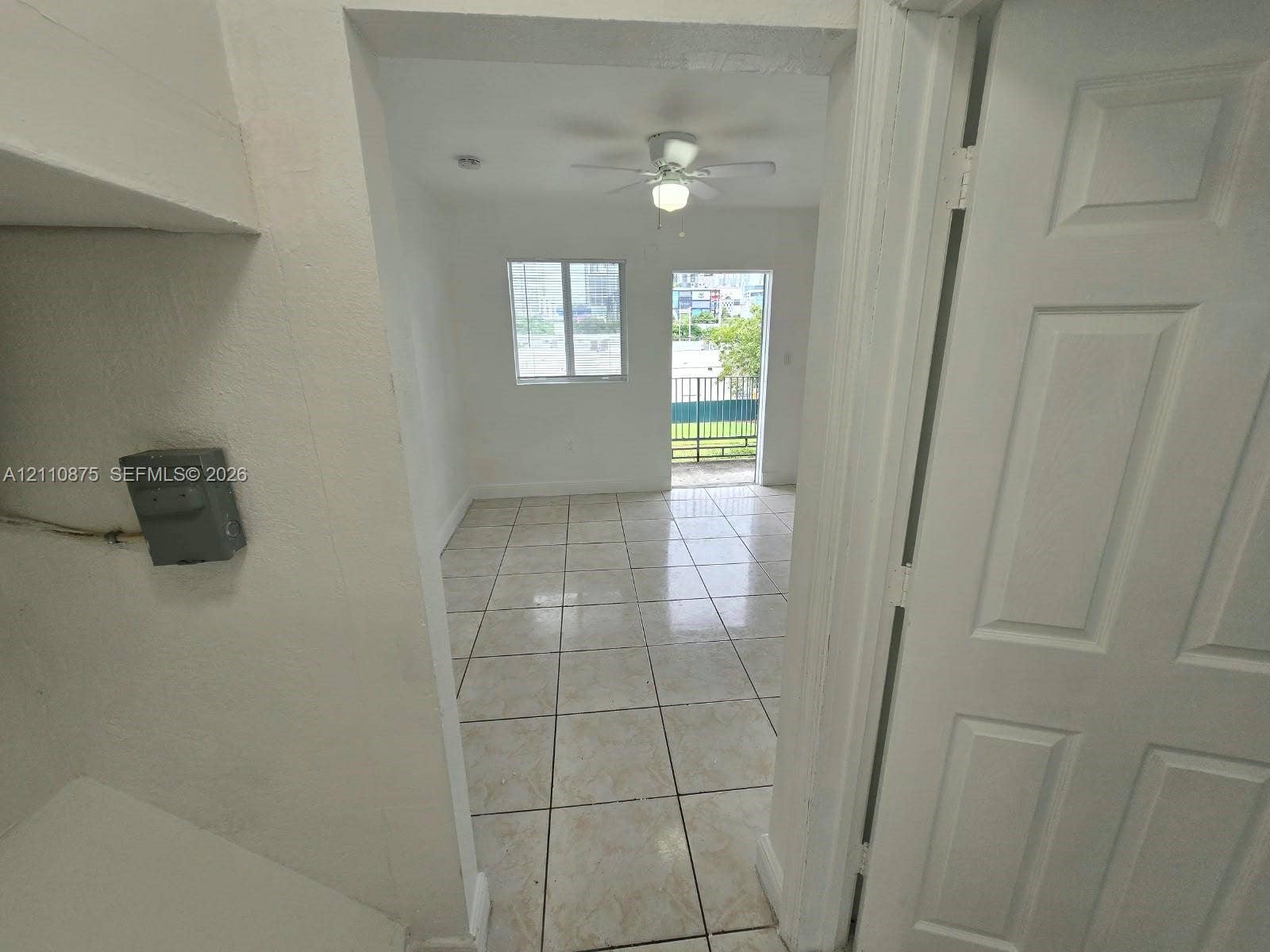 535 NW 7th Street, #10, Miami, Miami, FL 33136 Interior space featuring ceramic tile flooring, a central ceiling fan with integrated lighting, and a glass-paneled exterior door